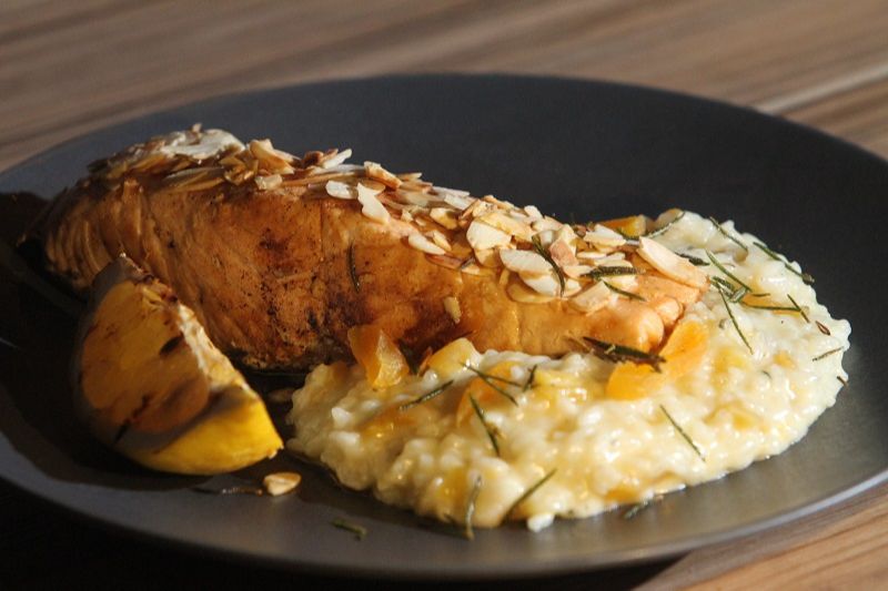 O Barão Vermelho é a sugestão de prato assado do By Rock, na Praia do Canto. A iguaria é composta de salmão com crosta de amêndoas, acompanhado de risoto de damasco e gorgonzola (individual, por R$ 55,00). Disponível para almoço e delivery pelo iFood. (Foto: Beto morais/AT)