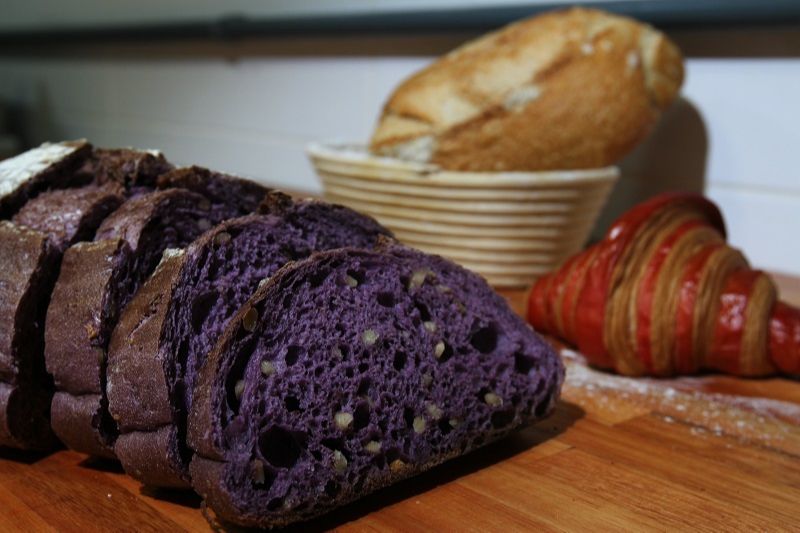 Pão roxo de nozes e bicolor da Lartigiano Panetteria, em Vila Velha. (Foto: Dayana Souza/AT)