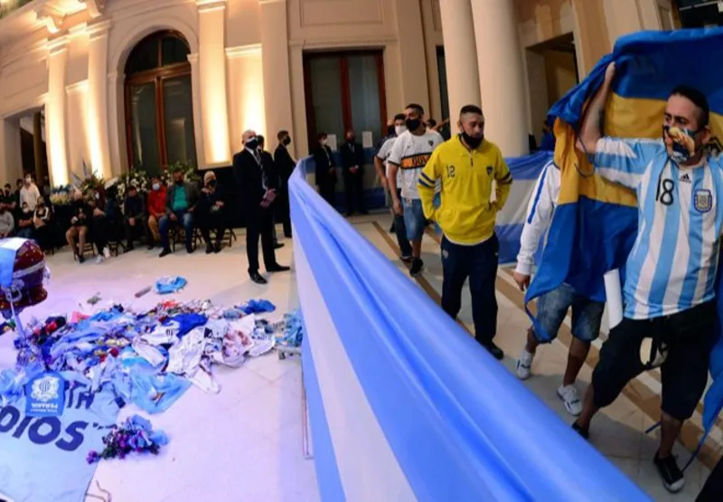 Torcedores passam diante do caixão com o corpo do ex-jogador Diego Armando Maradona