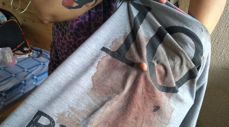 Mãe da vítima mostra a camisa da filha suja de sangue e com buracos das facadas (Foto: Fábio Nunes/AT)