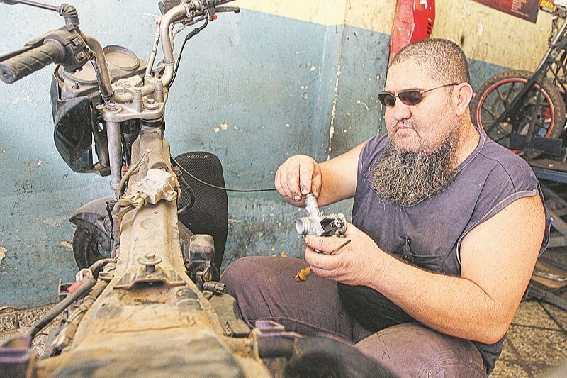 Mecânico Dalmir Evangelista trabalha na própria oficina, na Serra. Ele ficou cego há 5 anos, após acidente de moto (Foto: Kadidja Fernandes/ AT)