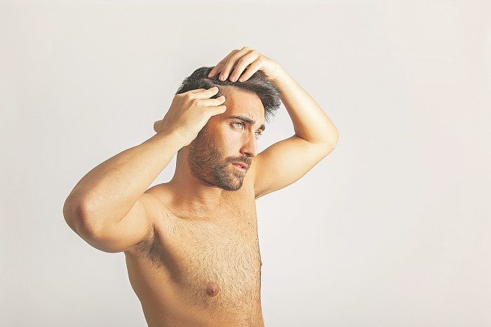 Homem avalia queda dos fios: estudo diz que 45,2% dos pacientes em tratamento de calvície têm entre 26 e 35 anos (Foto: Freepik)