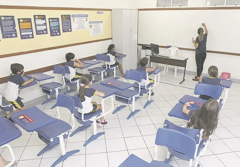 Crianças em sala de aula adaptada para atividades presenciais e a distância