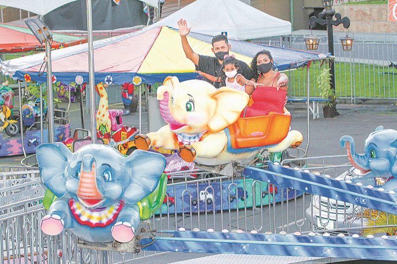 O casal Evandro Caldeira e Laís Soares se diverte com a filha, Luíza, 3 anos, em brinquedo de parque em área aberta (Foto: Leone Iglesias/ AT)