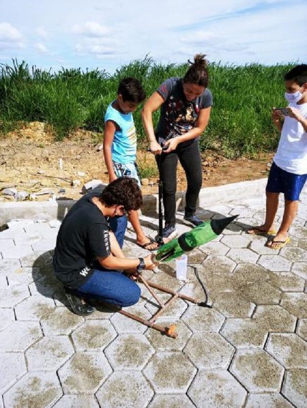 Isaac (agachado), Leovictor (camisa azul) e Débora preparam lançamento de foguete (Foto: Divulgação )