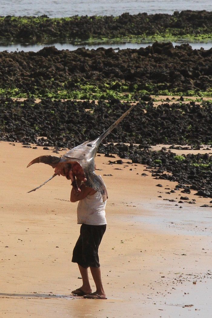 Morador carrega pedaço do peixe (Foto: Kadidja Fernandes/AT)