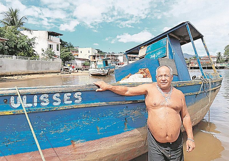 Pirata Portela ao lado do seu barco “Ulisses”: meta do pescador agora é trocar o motor da embarcação, que já tem quase 30 anos (Foto: Roberta Bourguignon)
