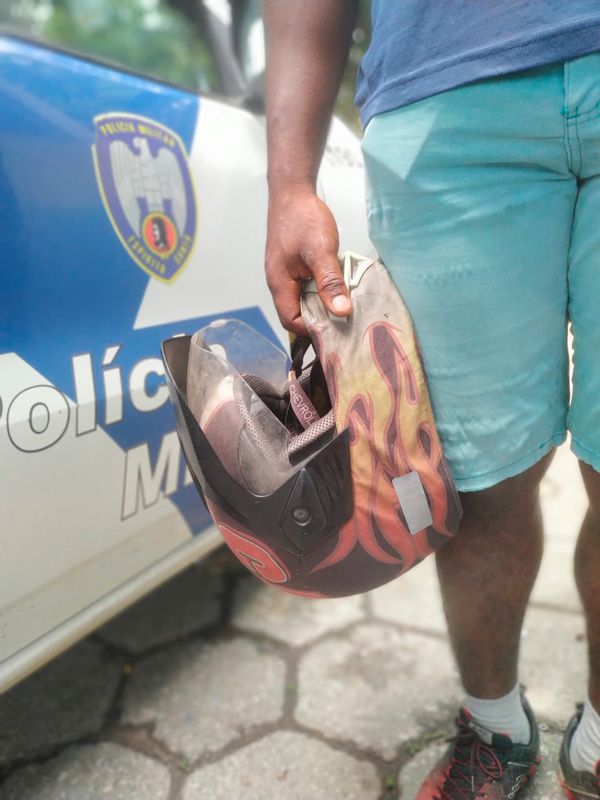 Vítima segurando o único objeto que restou do roubo: o seu capacete (Foto: Kananda Natiely / AT)