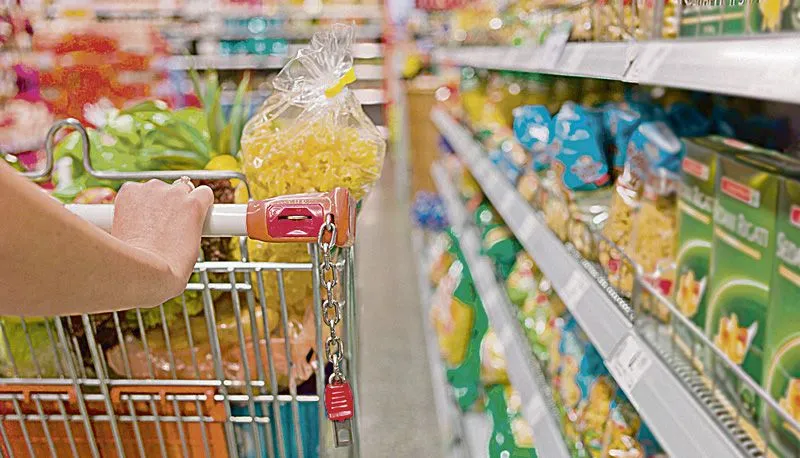 Consumidor em supermercado: alta de preços causada pelo aumento do dólar, exportações e fatores ligados ao clima