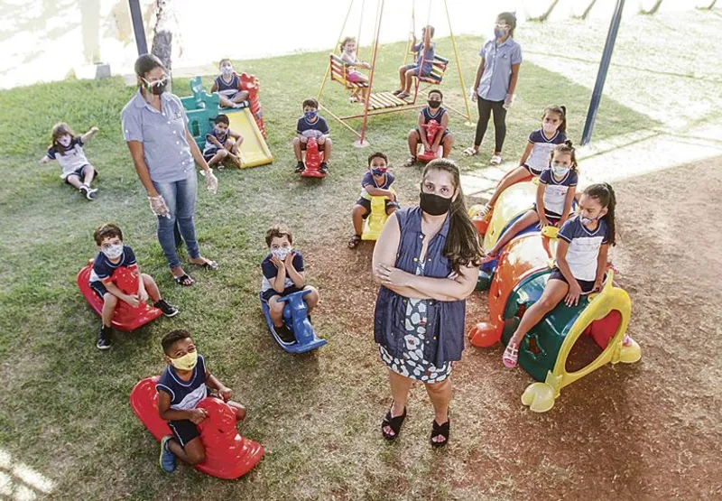 Com máscaras, crianças se divertem em colônia de férias de creche