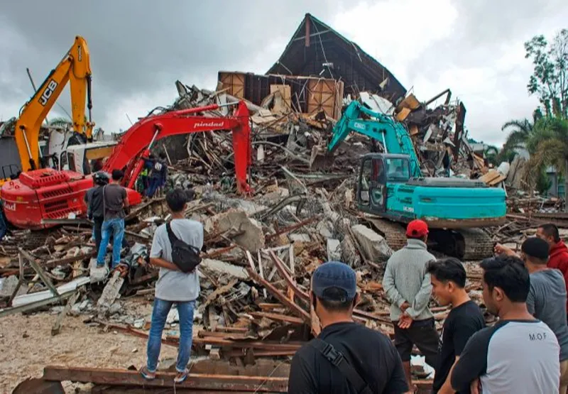 Equipes de resgate procuram sobreviventes entre as ruínas de um prédio danificado por um terremoto em Mamuju, no lado Ocidental da Sulawesi, na Indonésia