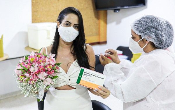 A enfermeira foi imunizada ainda vestida de noiva 20 minutos depois de se casar (Foto: Fernando Diniz)