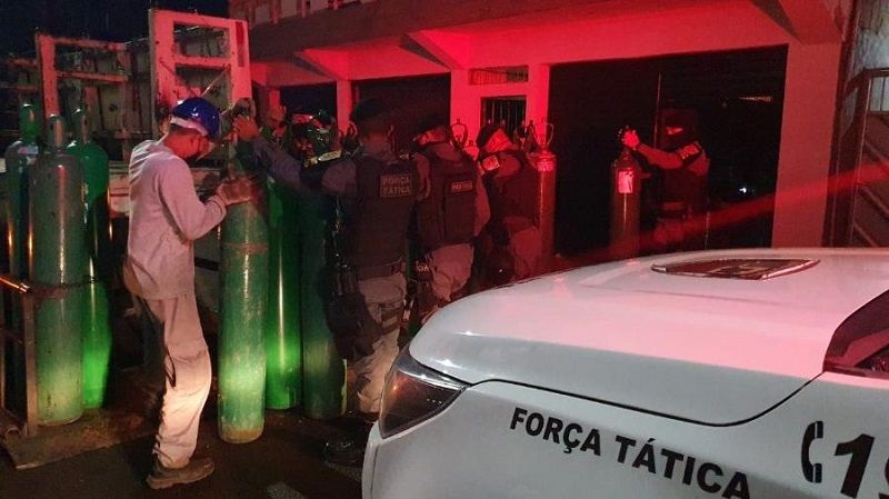 Policiais e a carga de cilindros de Oxigênio apreendia em Manaus (Foto: Divulgação/Força Tática da PMAM)