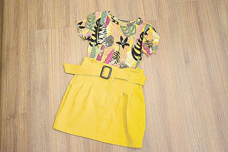 Blusa com estampa de flores, de R$ 59,90 por R$ 39,90. Saia amarela com cinto, de R$ 79,90 por R$ 39,90. (Foto: Divulgação)