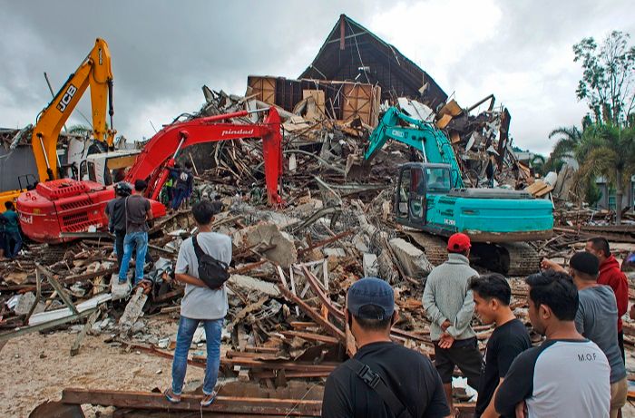 Equipes de resgate procuram sobreviventes entre as ruínas de um prédio danificado por um terremoto em Mamuju, no lado Ocidental da Sulawesi, na Indonésia (Foto: AZHARI SURAHMAN/ASSOCIATED PRESS/ESTADÃO CONTEÚDO)