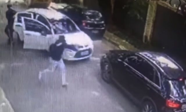 Uma câmera de monitoramento registrou o momento em que a vítima foi abordada. (Foto: Reprodução / TV)