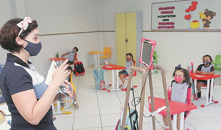 A professora Tatiana Siqueira durante aula em escola, também transmitida de forma online para alunos em casa (Foto: Leone Iglesias/AT)