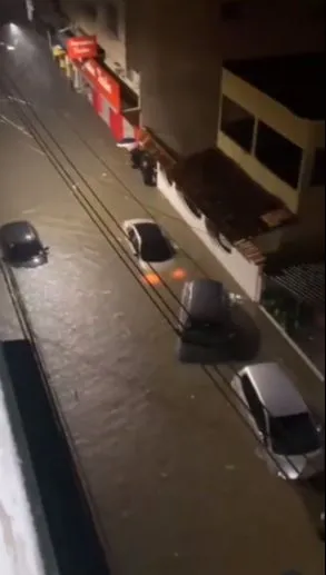 Carros submersos em rua do bairro Campo Grande