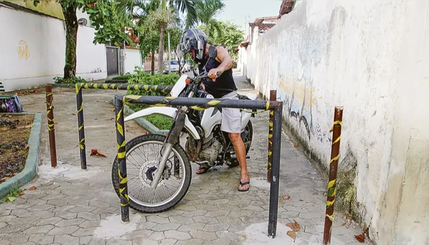 Motociclista simula como barras de ferro, instaladas por Associação de Moradores, impedem a passagem irregular de motos em bairro de Vitória