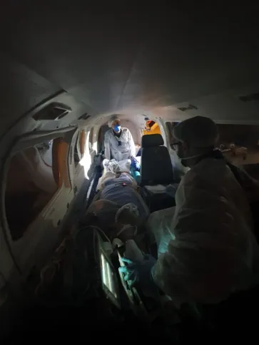 Equipe dentro da aeronave com paciente 