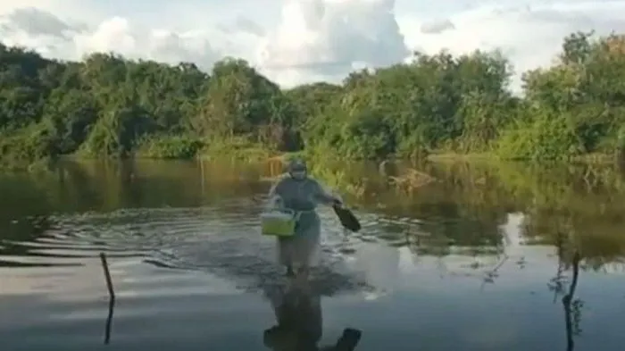 Imagem ilustrativa da imagem Enfermeira atravessa rio a pé para vacinar idosa contra Covid
