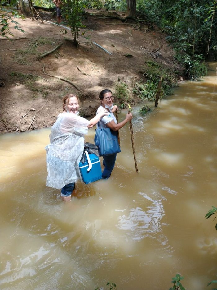 Lucilene segura a caixa térmica onde está a dose da vacina da idosa e é guiada por Elza (Foto: Acervo pessoal)