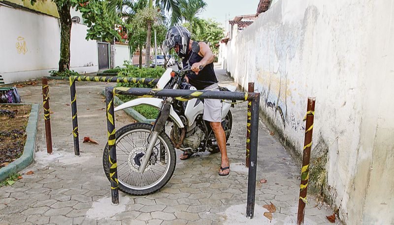 Motociclista simula como barras de ferro, instaladas por Associação de Moradores, impedem a passagem irregular de motos em bairro de Vitória (Foto: Fábio Nunes / AT)