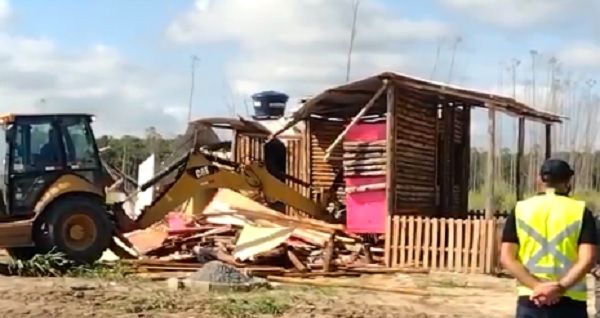 Trator derrubou barracos onde moravam as famílias (Foto: Reprodução vídeo)