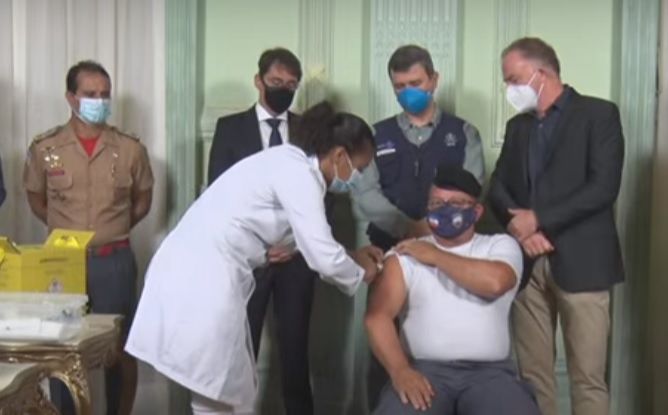 O primeiro a ser vacinado foi o sargento De Souza, da Polícia Militar. (Foto: Reprodução/Youtube)