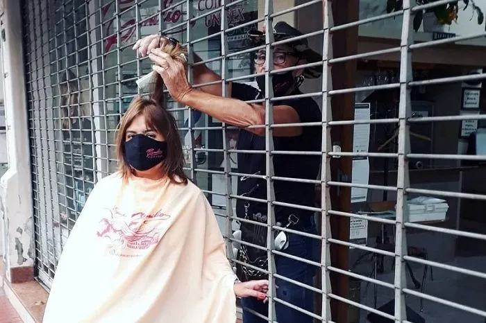 Imagem ilustrativa da imagem Contra lockdown, dono de salão viraliza com corte de cabelo pela grade