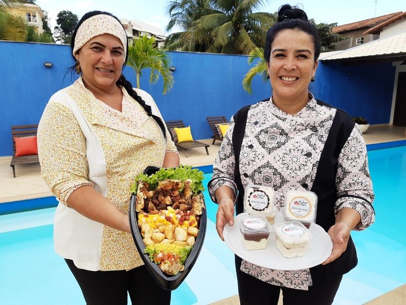 As comerciantes Andreia Braga e Fernanda Braga seguram, a barca de espetos e opções de bolo no pote que também são vendidos no festival. - Elas são do Spettu’s Express (Foto: Roberta Bourguignon)