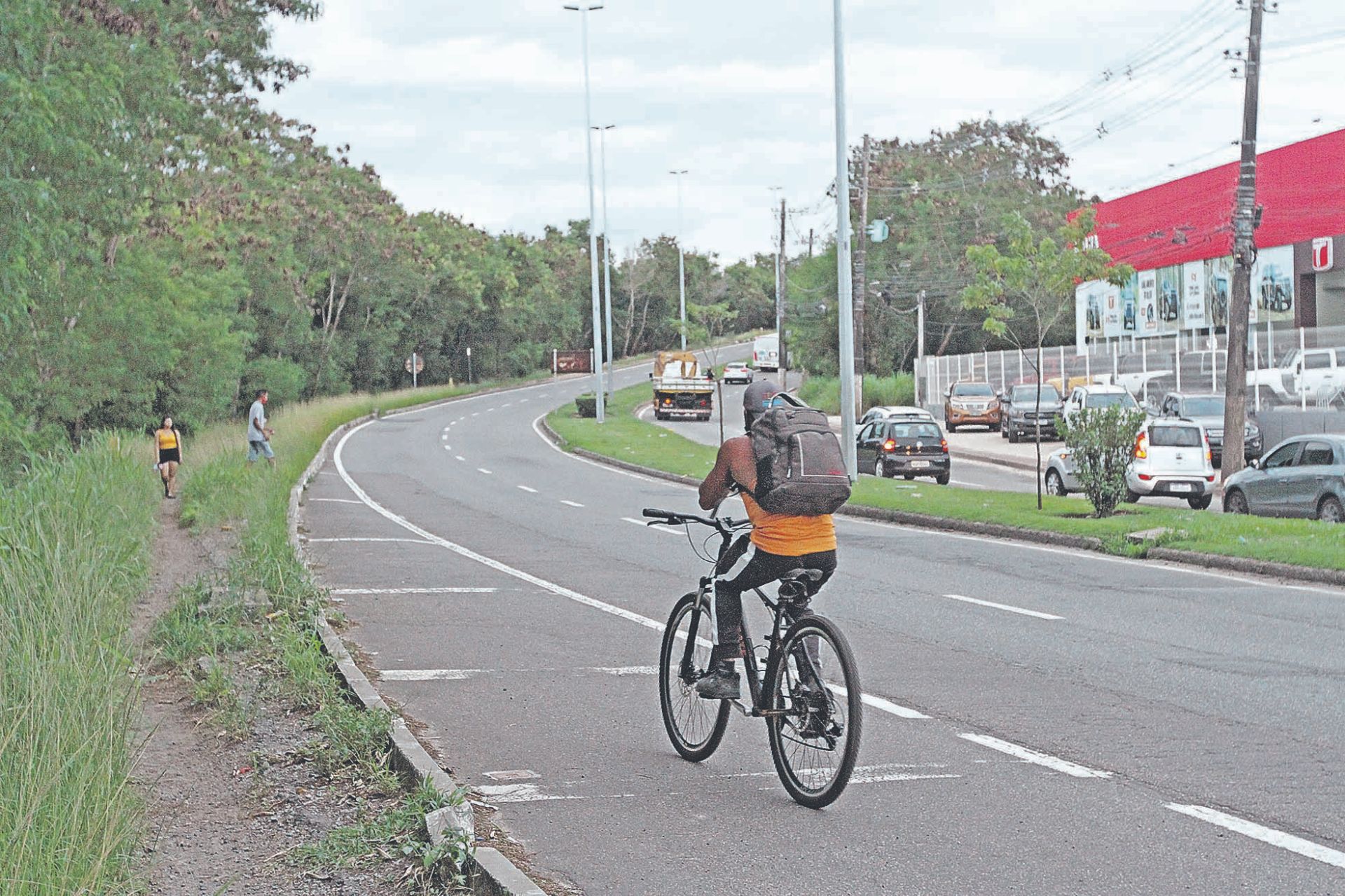 Ciclista se arrisca em trecho da rodovia Norte-Sul que não tem ciclovia e nem calçada para os pedestres (Foto: Beto Morais/ AT)