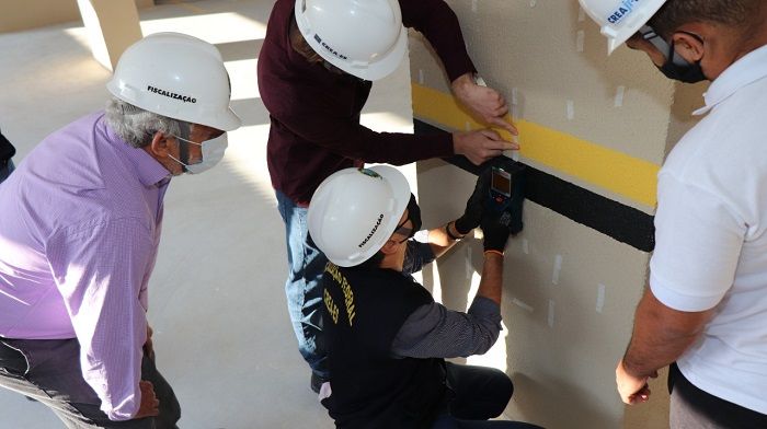 Técnicos utilizam um aparelho para escanear o interior da pilastra (Foto: Divulgação Crea-ES)