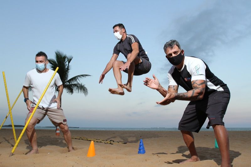 O professor Wagner Nunes (à direita), do projeto Vila Velha Ativa, orienta alunos em atividade na Praia da Costa: bem-estar e saúde (Foto: Beto Morais/AT)