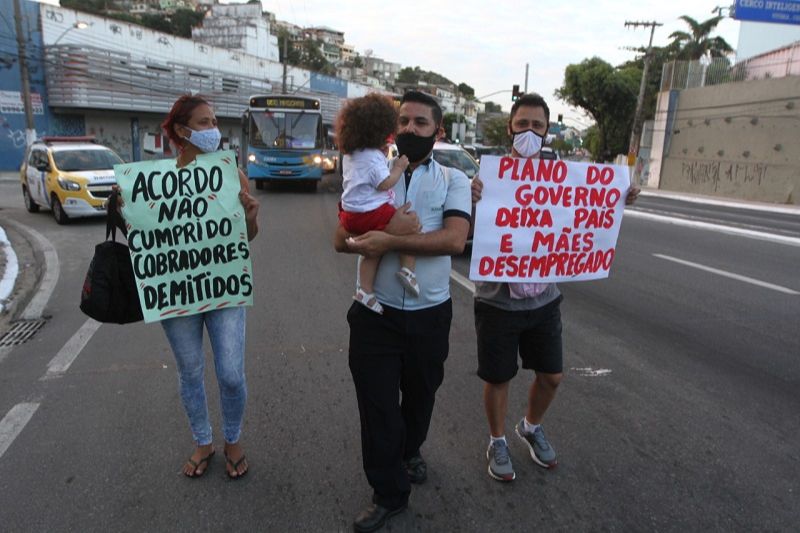 Manifestantes mostram cartaz reivindicando volta ao trabalho (Foto: Antônio Moreira/AT)