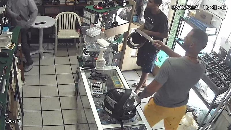 Um dos criminosos usou uma faca para ameaçar o lojista. Os dois foram flagrados pela câmera de segurança (Foto: Reprodução)
