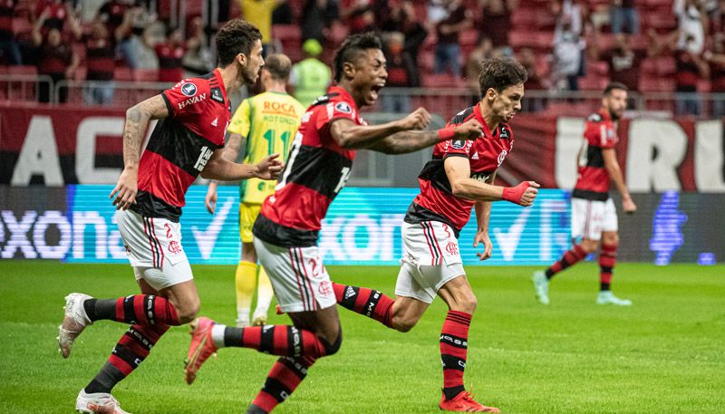 Rodrigo Caio (à frente) corre com Bruno Henrique e Gustavo Henrique para comemorar o primeiro gol do jogo (Foto: Alexandre Vidal / Flamengo)