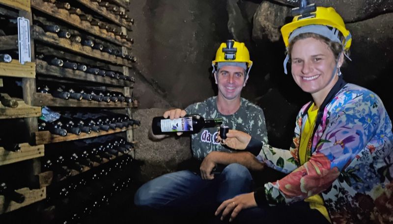 Paulo César e Ana Júlia saboreiam vinho dentro da caverna, após passarem por vários obstáculos até o local (Foto: Roberta Bourguignon / AT)