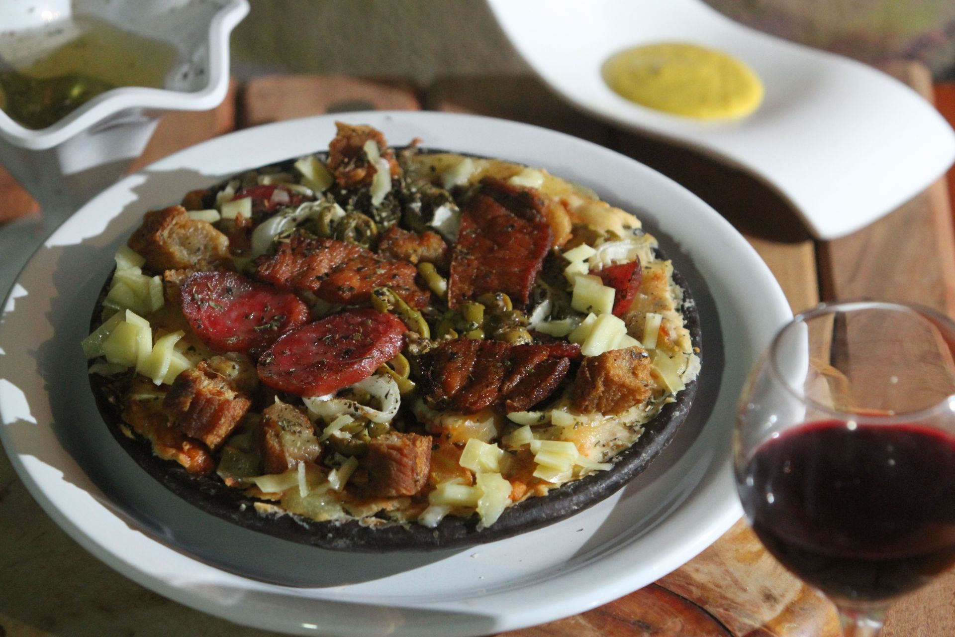 A pizza de boteco leva torresmo, bacon, queijo, linguicinha defumada, barriguinha e azeitonas. (Foto: Beto Morais/AT)