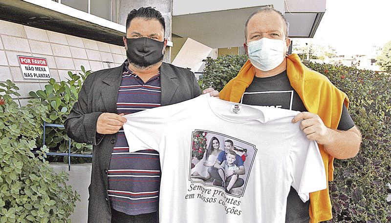 Ricardo Porto e Roberto Cole seguram camisa que traz a foto de Cabo Porto, da mulher e do filho do vereador (Foto: Antonio Moreira / AT)