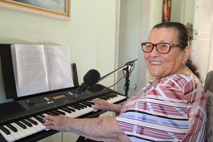 A professora aposentada Rosa Maria Gomes, 85, tem o hobby de cantar e tocar teclado, violão e até acordeon (Foto: Kadidja Fernandes/AT)