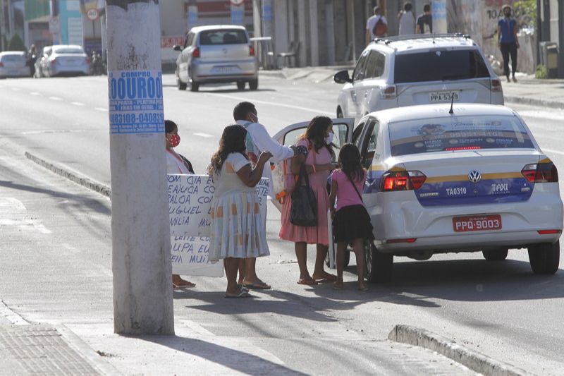 Com um cartaz pedindo ajuda, família de índios venezuelanos conversa com taxista em rua de Vila Velha (Foto: Fábio Nunes/ AT)