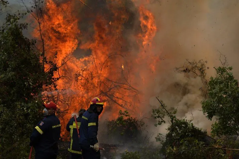 Bombeiros tentavam extinguir o fogo ao norte de Atenas, na Grécia, na manhã de segunda. Incêndios devastam região