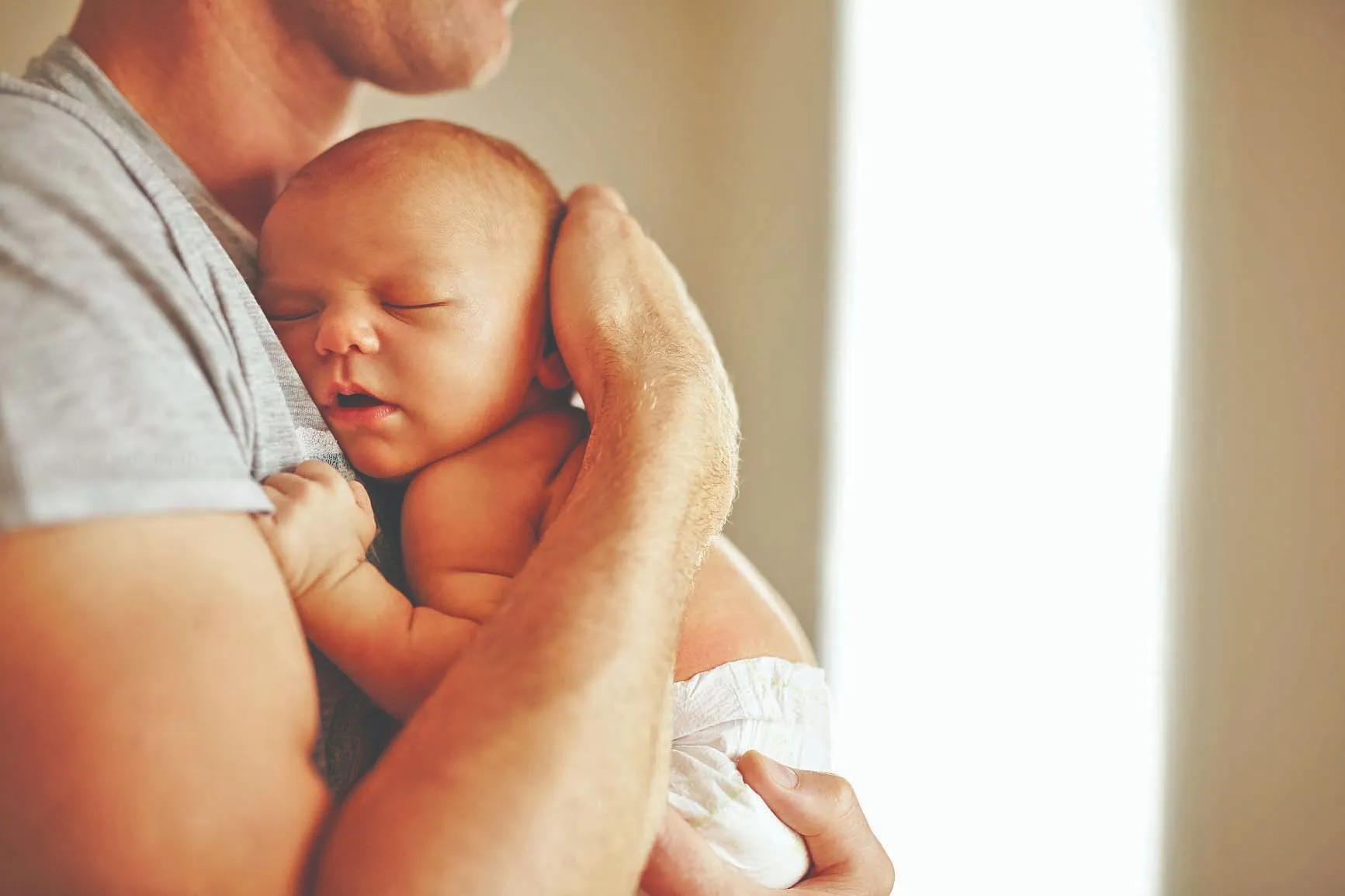 Pai com bebê no colo: CLT garante 5 dias de afastamento após nascimento do filho. Programa amplia para 20
