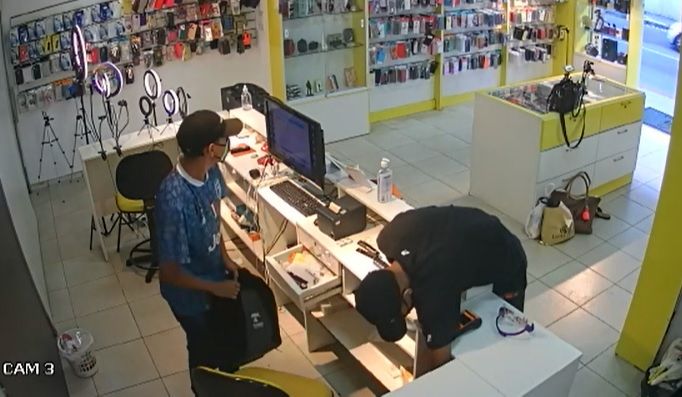 Bandidos roubam aparelhos de celular enquanto comparsa mantém vítimas reféns (Foto: Reprodução vídeo)