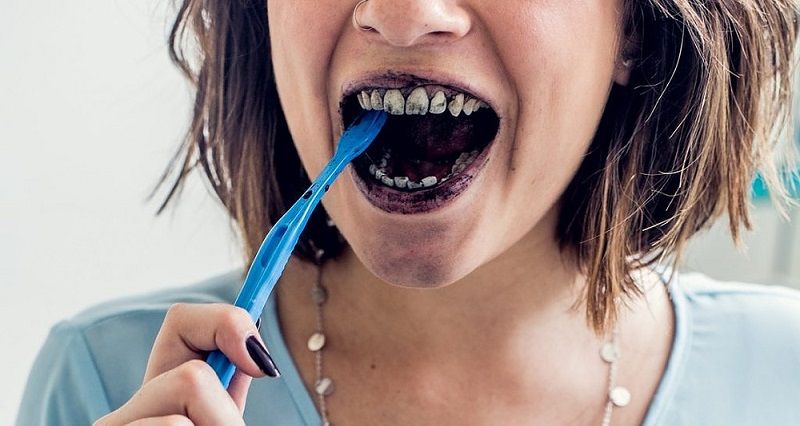 Mulher realizando técnica de clareamento caseiro dos dentes (Foto: Divulgação)