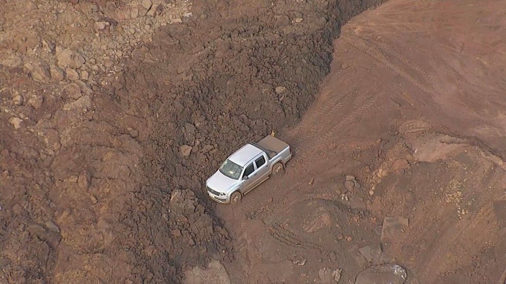 Um carro foi soterrado após deslizamento de terra em Sarzedo (Foto: TV Globo)