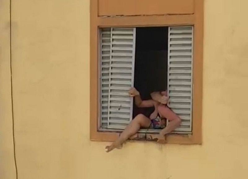 Um vídeo gravado pelos vizinhos do agressor mostra uma mulher, de 35 anos, que está grávida de três meses, tentando pular do segundo andar do prédio onde morava para se livrar da violência (Foto: Reprodução/ Redes Sociais)