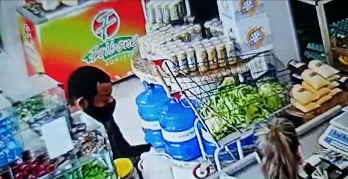Bandido rendeu funcionária, levou dinheiro e fardo de cerveja (Foto: Reprodução vídeo)