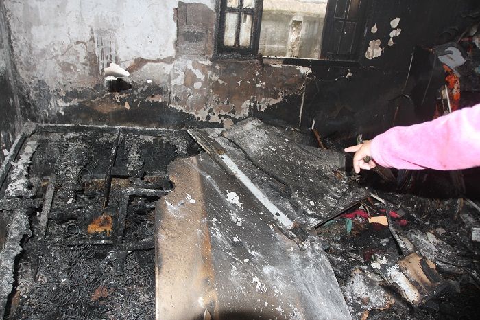 Cuidadora aponta para objetos queimados no incêndio (Foto: Antonio Moreira/AT)